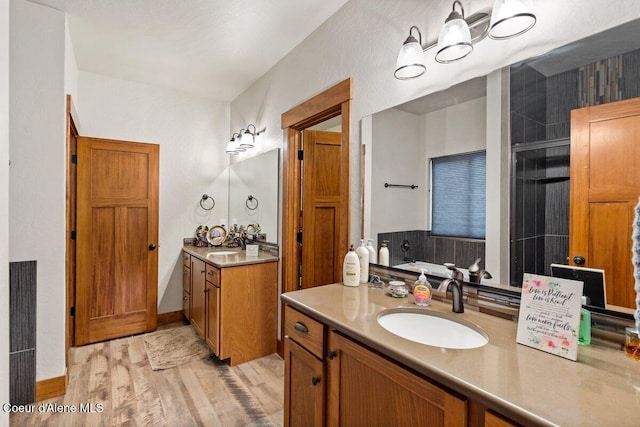 bathroom featuring vanity, hardwood / wood-style flooring, and a shower with door