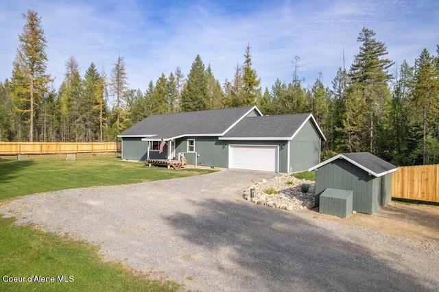 view of front of property featuring a shed, a front yard, and a garage