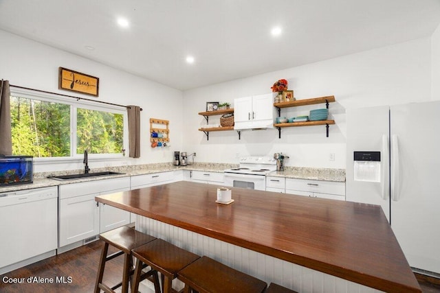 kitchen with white appliances, dark wood-type flooring, sink, and white cabinets