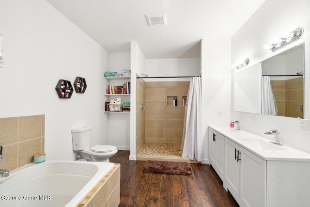 full bathroom with vanity, toilet, hardwood / wood-style flooring, and separate shower and tub