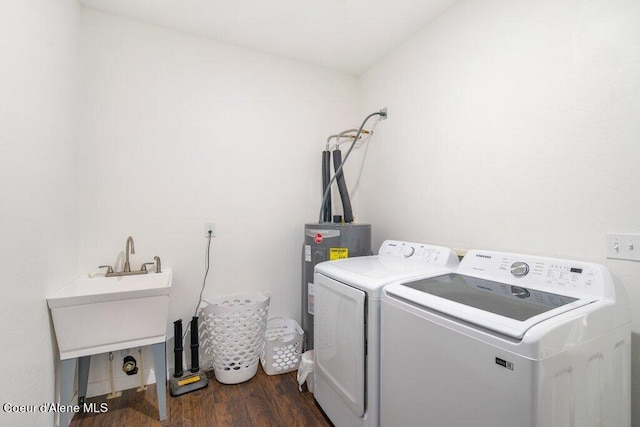 laundry area featuring sink, electric water heater, separate washer and dryer, and dark hardwood / wood-style flooring