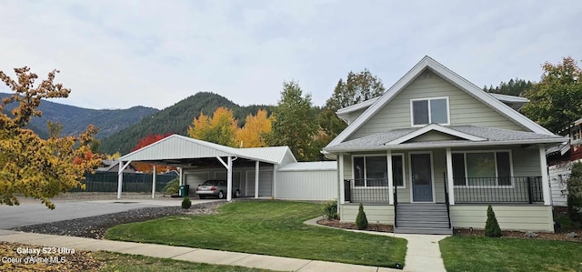 bungalow with a mountain view, a porch, a carport, and a front yard