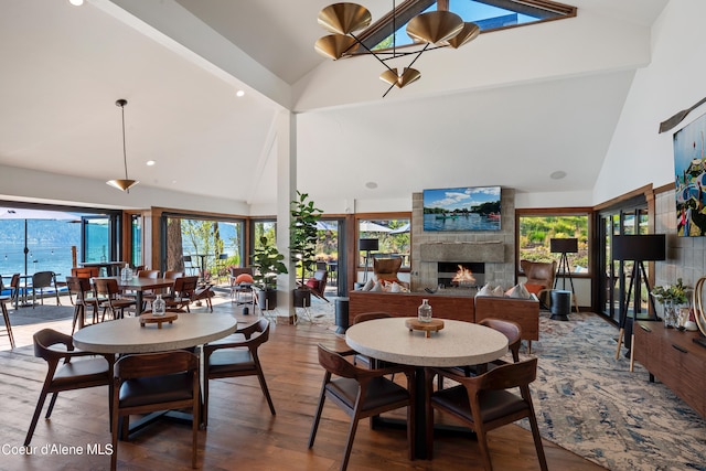 15374 S Chalone Dr, Coeur Dalene, ID 83814 - dining space with wood finished floors, high vaulted ceiling, a large fireplace, and recessed lighting