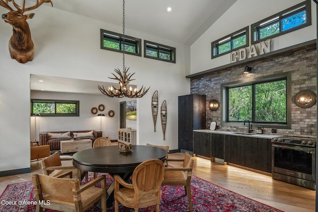 15374 S Chalone Dr, Coeur Dalene, ID 83814 - dining space featuring baseboards, high vaulted ceiling, a chandelier, and light wood-style floors