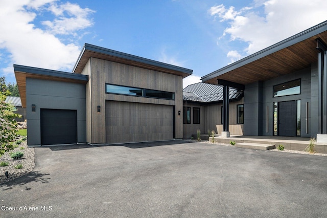 15374 S Chalone Dr, Coeur Dalene, ID 83814 - contemporary home featuring asphalt driveway, an attached garage, a metal roof, and a standing seam roof