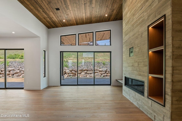 15374 S Chalone Dr, Coeur Dalene, ID 83814 - unfurnished living room featuring a high ceiling, wood ceiling, plenty of natural light, light wood-type flooring, and a tiled fireplace