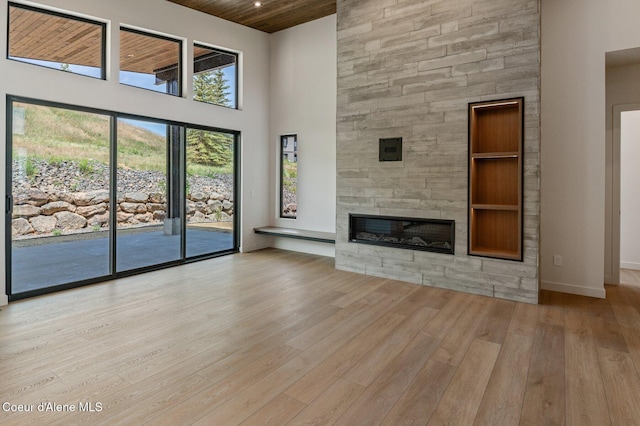 15374 S Chalone Dr, Coeur Dalene, ID 83814 - unfurnished living room featuring a towering ceiling, wood finished floors, a fireplace, and wood ceiling
