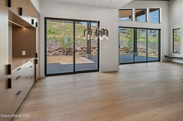 15374 S Chalone Dr, Coeur Dalene, ID 83814 - unfurnished dining area with light wood-style floors, a chandelier, and a towering ceiling