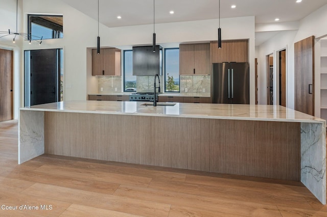 15374 S Chalone Dr, Coeur Dalene, ID 83814 - kitchen featuring freestanding refrigerator, light wood-style floors, a large island, recessed lighting, and backsplash