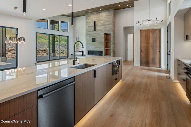 15374 S Chalone Dr, Coeur Dalene, ID 83814 - kitchen with dishwashing machine, a towering ceiling, open floor plan, light wood finished floors, and a fireplace