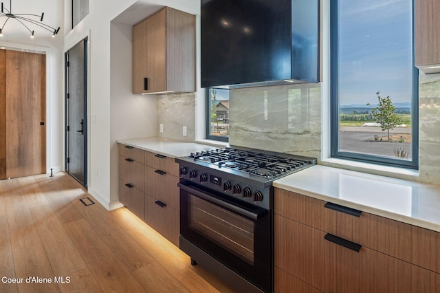 15374 S Chalone Dr, Coeur Dalene, ID 83814 - kitchen featuring black range with gas stovetop, light wood-type flooring, decorative backsplash, and light countertops