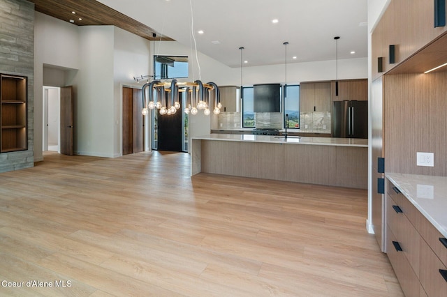 15374 S Chalone Dr, Coeur Dalene, ID 83814 - kitchen with freestanding refrigerator, modern cabinets, open floor plan, light countertops, and a towering ceiling