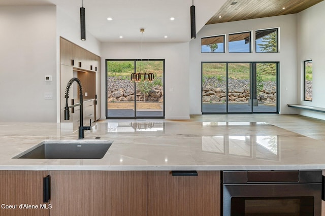 15374 S Chalone Dr, Coeur Dalene, ID 83814 - kitchen with light stone counters, open floor plan, wall oven, recessed lighting, and modern cabinets