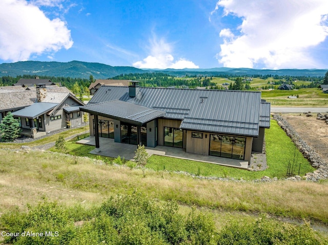 15374 S Chalone Dr, Coeur Dalene, ID 83814 - back of property with a patio, a chimney, and a metal roof