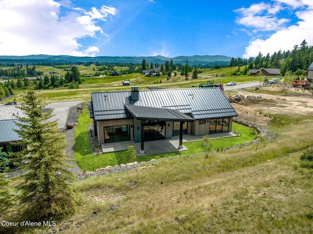 15374 S Chalone Dr, Coeur Dalene, ID 83814 - back of house featuring a mountain view, a patio area, a standing seam roof, and a metal roof