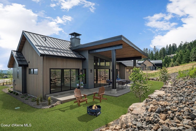 15374 S Chalone Dr, Coeur Dalene, ID 83814 - rear view of property with a standing seam roof, a patio area, a chimney, a metal roof, and a fire pit