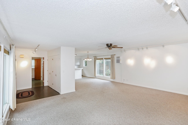 unfurnished living room with carpet flooring, a textured ceiling, and ceiling fan