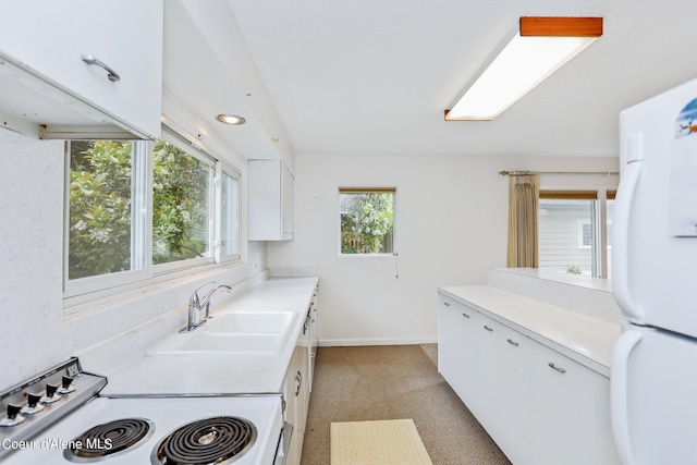 kitchen with plenty of natural light, white appliances, sink, and white cabinets