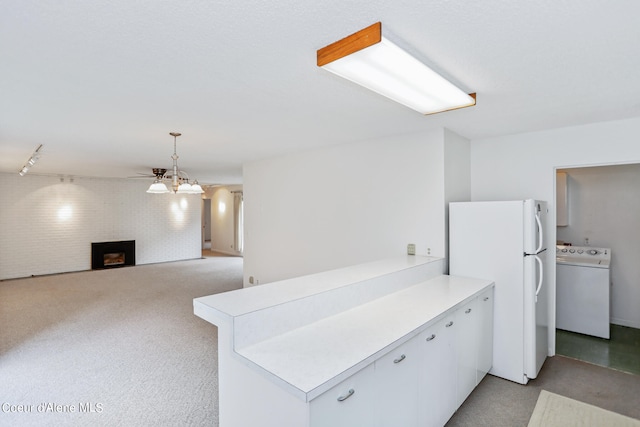 kitchen featuring white refrigerator, ceiling fan, kitchen peninsula, washer / clothes dryer, and white cabinetry