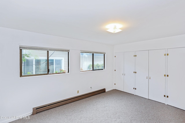 unfurnished bedroom featuring carpet and a baseboard heating unit