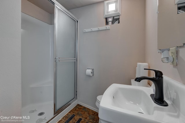 bathroom with toilet, a shower with door, and sink