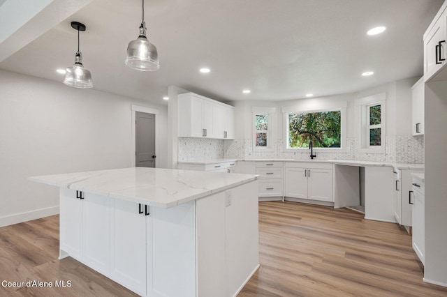 kitchen with light hardwood / wood-style floors, white cabinets, and a center island