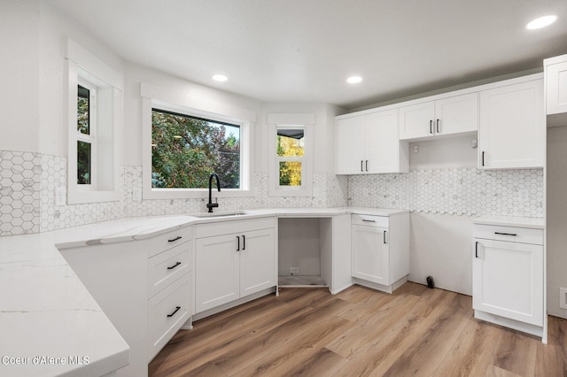 kitchen with white cabinetry, light hardwood / wood-style flooring, and sink