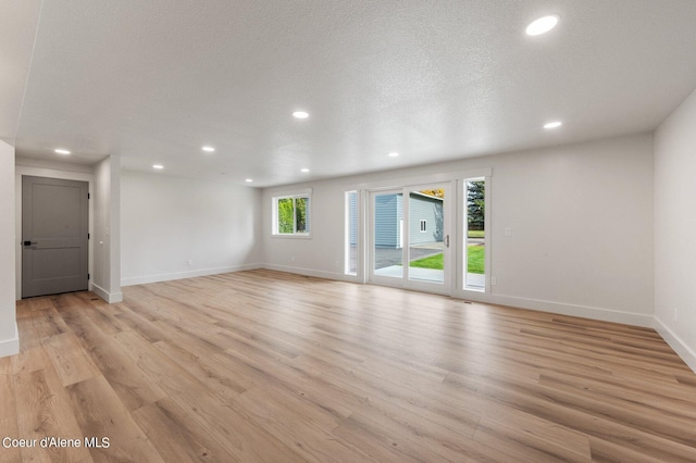 unfurnished room featuring a textured ceiling and light wood-type flooring