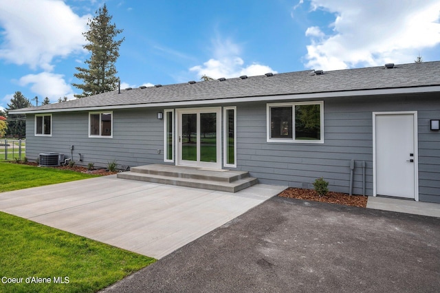 back of property featuring central air condition unit, a patio area, and a lawn