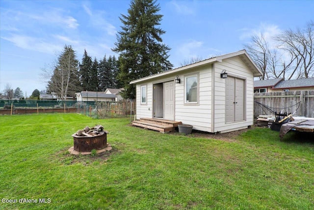 exterior space with a storage unit, a fire pit, and a lawn