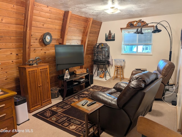 living room with a textured ceiling, wooden walls, and light colored carpet