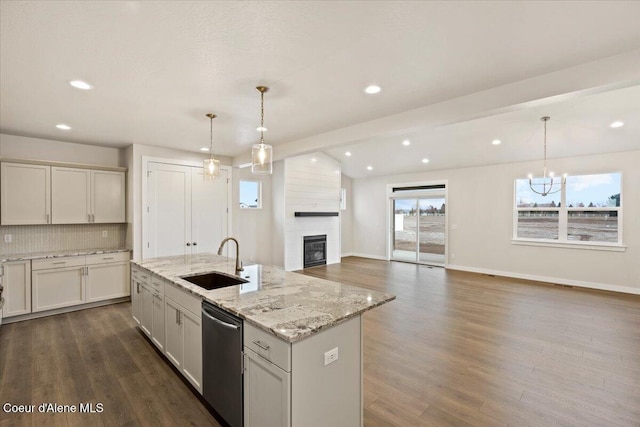 kitchen featuring dark hardwood / wood-style flooring, dishwasher, sink, and an island with sink