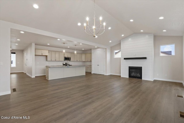 unfurnished living room with a fireplace, dark wood-type flooring, a chandelier, and lofted ceiling