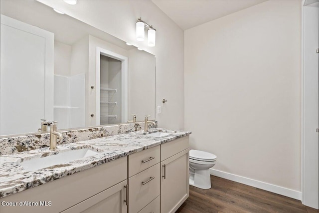 bathroom featuring walk in shower, toilet, vanity, and hardwood / wood-style flooring