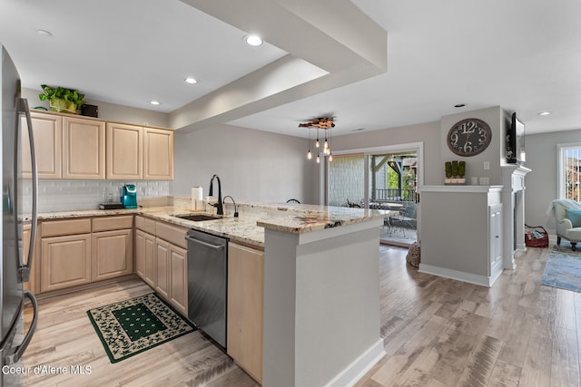 kitchen with sink, appliances with stainless steel finishes, a wealth of natural light, and kitchen peninsula