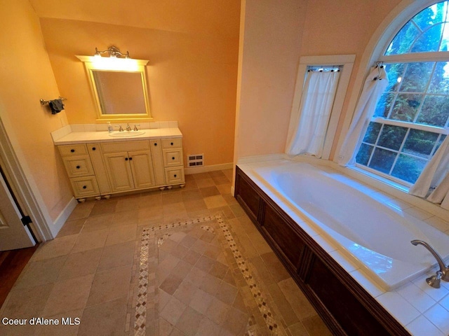 bathroom featuring vanity, tile patterned floors, and a bathtub