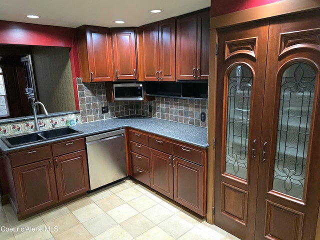 kitchen featuring sink, stainless steel appliances, light tile patterned floors, and tasteful backsplash