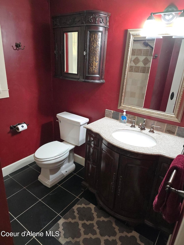 bathroom with toilet, vanity, and tile patterned flooring