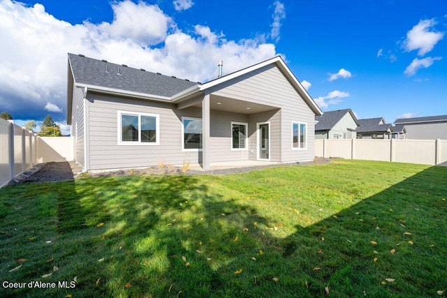 rear view of property featuring a patio area and a lawn