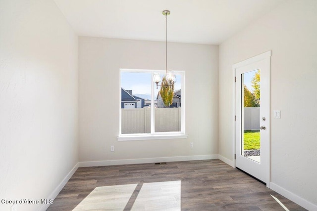 unfurnished dining area featuring a healthy amount of sunlight and dark hardwood / wood-style flooring