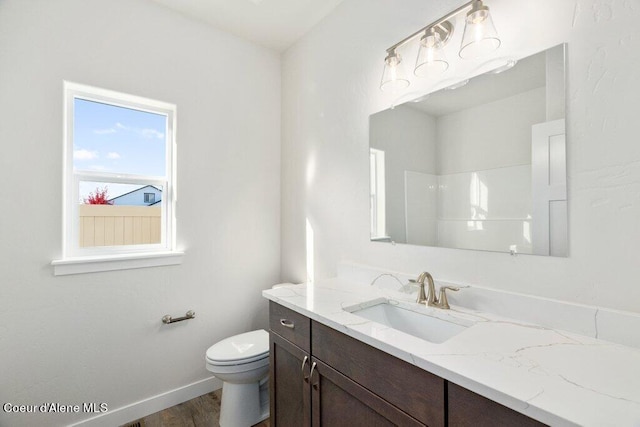 bathroom featuring toilet, hardwood / wood-style flooring, and vanity