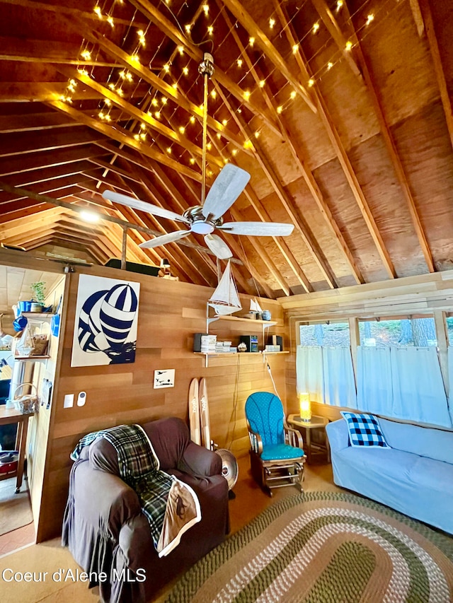 living room featuring ceiling fan, lofted ceiling, and wooden walls