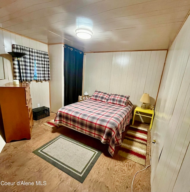 bedroom featuring wood walls and light wood-type flooring