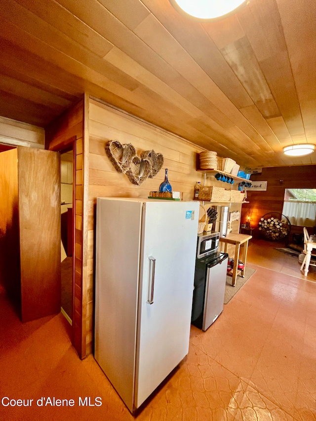 kitchen with wooden walls and white refrigerator