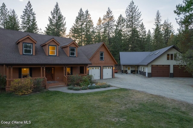 view of front of property with a porch, a front lawn, and a garage