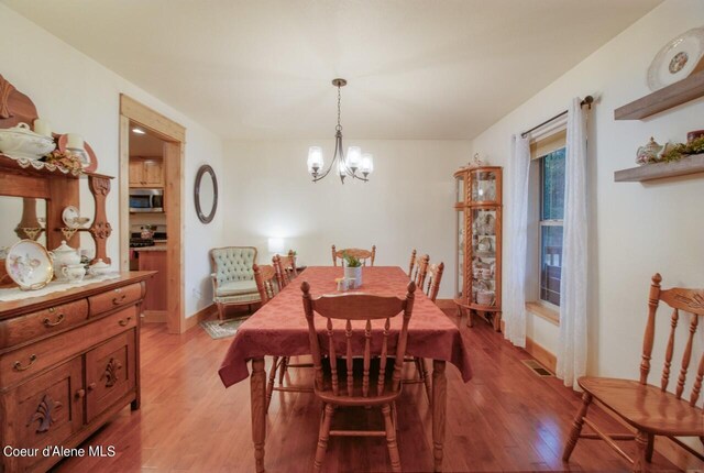 dining space with a chandelier and light wood-type flooring