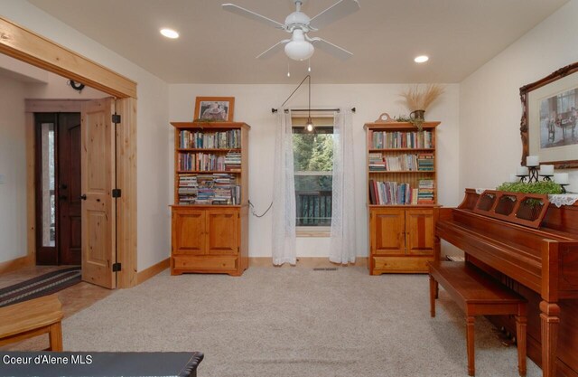 sitting room featuring light carpet and ceiling fan