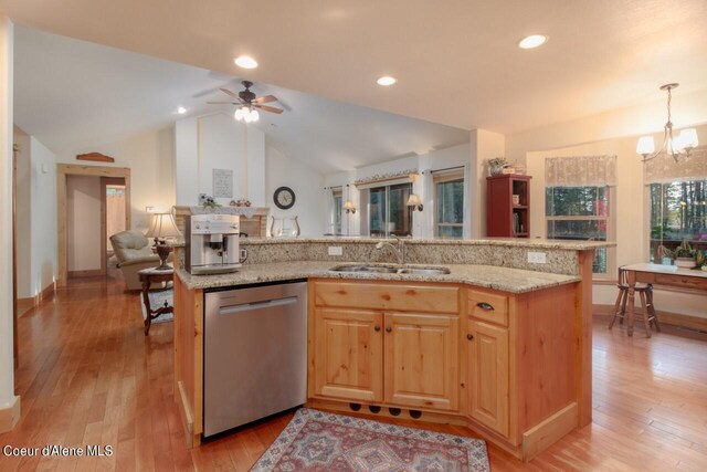 kitchen featuring dishwasher, sink, light stone countertops, vaulted ceiling, and light hardwood / wood-style floors