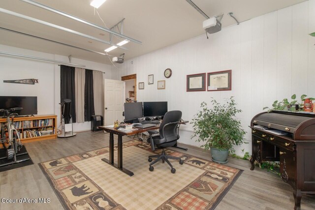 office area featuring wood walls and wood-type flooring