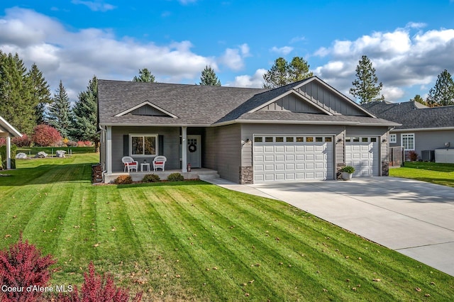 view of front of home with a front yard, cooling unit, and a garage